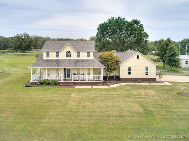 country-style home with covered porch, a front yard, and central AC unit