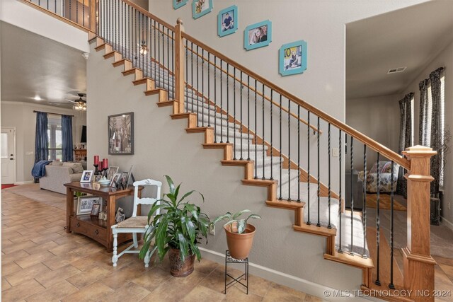 staircase featuring ceiling fan and tile patterned floors