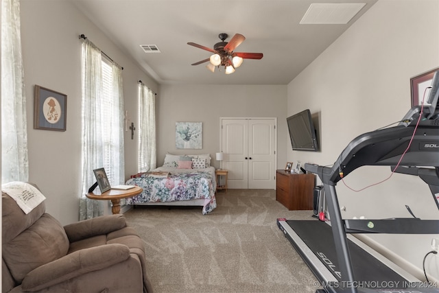 carpeted bedroom featuring ceiling fan and a closet