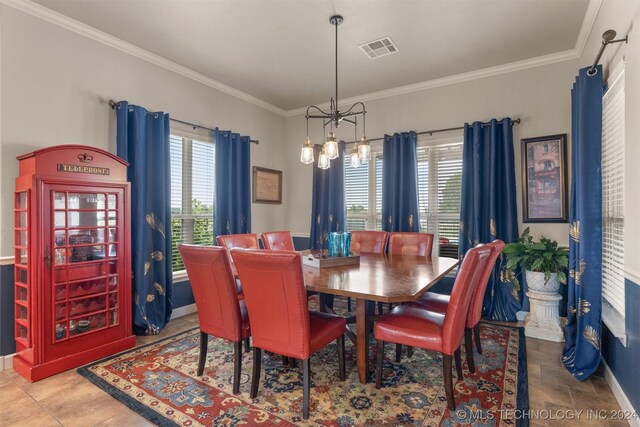 dining area featuring tile patterned flooring, a chandelier, and ornamental molding