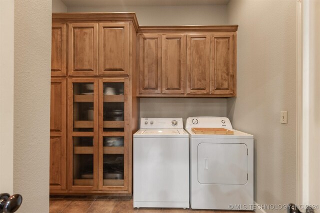 laundry area with washer and dryer and cabinets