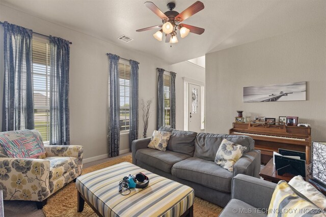 carpeted living room with a wealth of natural light and ceiling fan