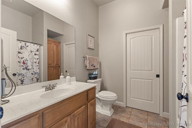 bathroom featuring tile patterned floors, vanity, and toilet