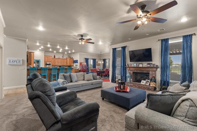 tiled living room featuring ceiling fan, crown molding, and a brick fireplace