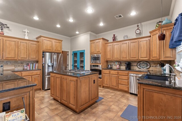 kitchen featuring sink, stainless steel appliances, decorative backsplash, and a center island