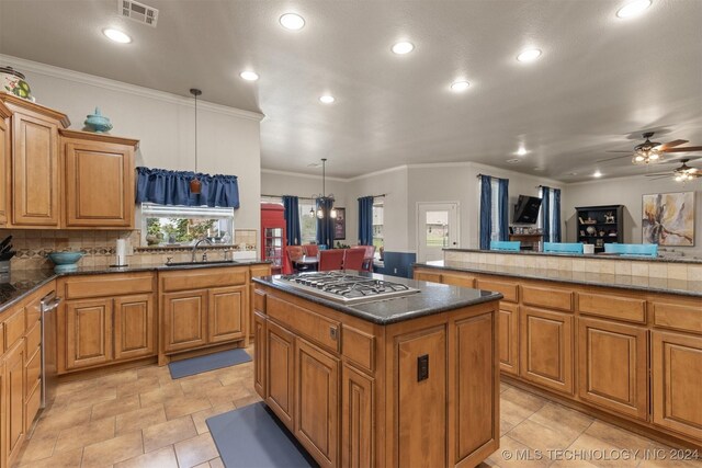 kitchen with ceiling fan, a kitchen island, light tile patterned flooring, and stainless steel gas cooktop