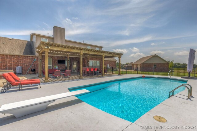 view of swimming pool featuring a patio area, a pergola, and a diving board