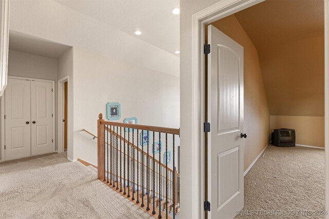 hall featuring light colored carpet and vaulted ceiling