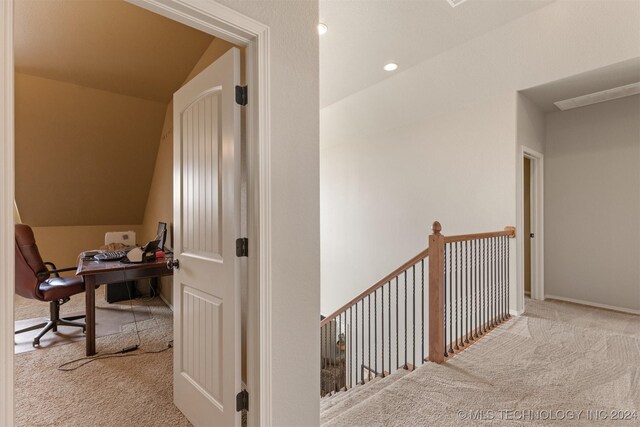 hall featuring lofted ceiling and light carpet