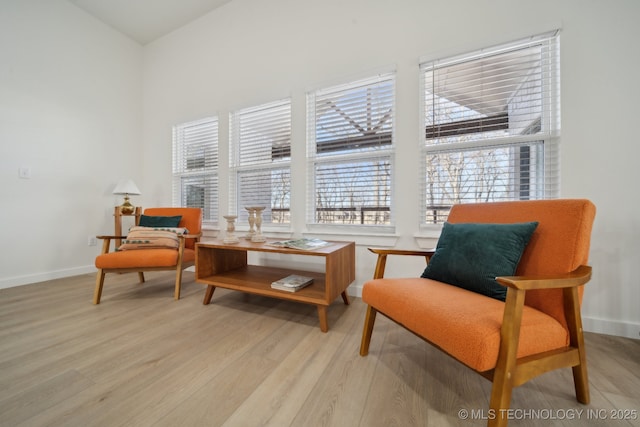 living area with vaulted ceiling and light hardwood / wood-style floors