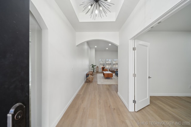 hallway featuring a chandelier and light hardwood / wood-style flooring