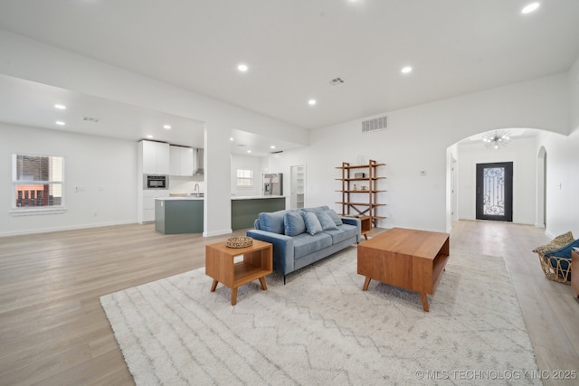 living room featuring sink and light hardwood / wood-style floors