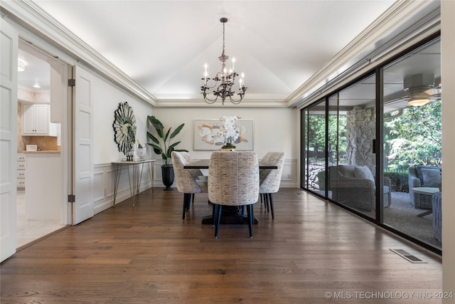 dining space with crown molding, lofted ceiling, a chandelier, and wood-type flooring