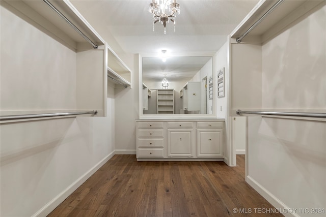 walk in closet featuring dark wood-type flooring and a chandelier