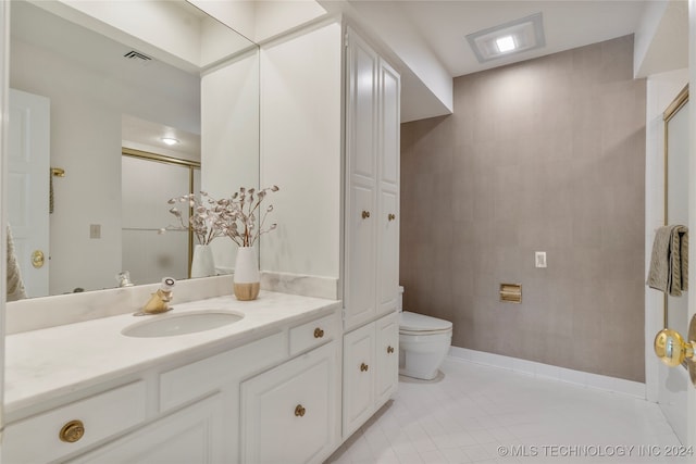 bathroom featuring a shower, tile patterned flooring, vanity, and toilet