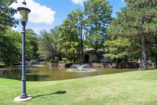 view of community featuring a water view and a lawn