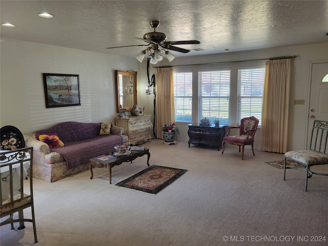 living room with a textured ceiling, carpet floors, and ceiling fan