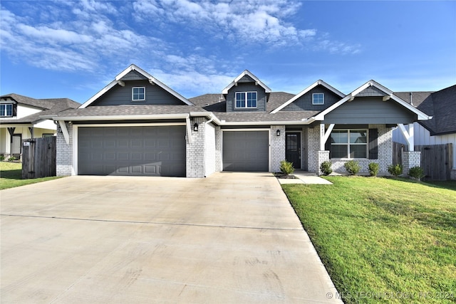 craftsman house with a garage, brick siding, fence, driveway, and a front yard