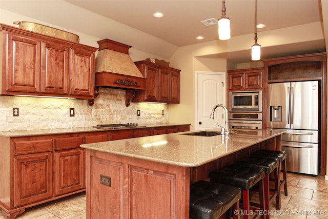 kitchen featuring light tile patterned flooring, stainless steel appliances, a center island with sink, and premium range hood