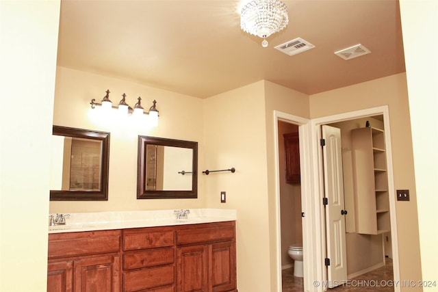 bathroom with toilet, vanity, and tile patterned floors