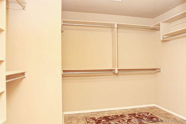 spacious closet with light tile patterned floors