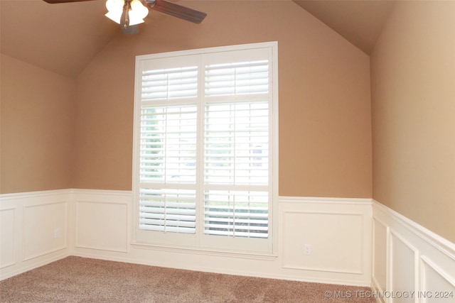 carpeted empty room with ceiling fan and vaulted ceiling