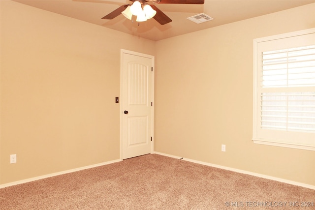 empty room featuring ceiling fan and light colored carpet