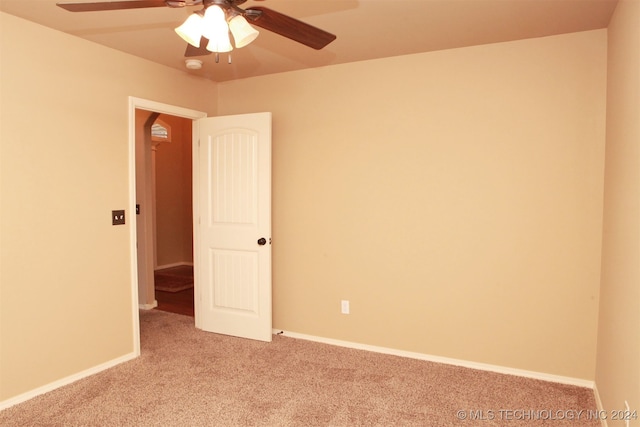 carpeted spare room featuring ceiling fan