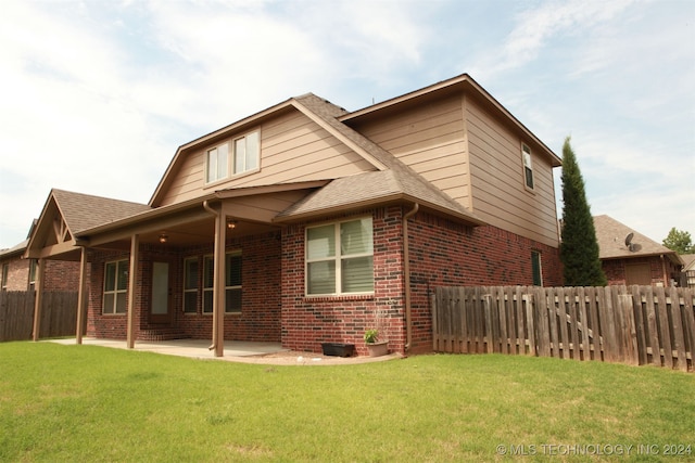 rear view of house with a patio area and a lawn