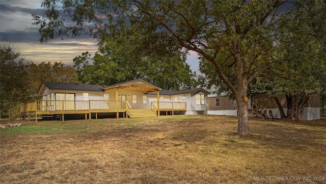 yard at dusk featuring a deck