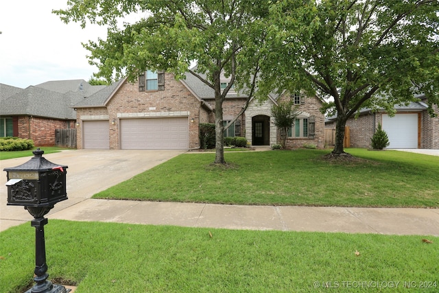 view of front of home with a front yard and a garage