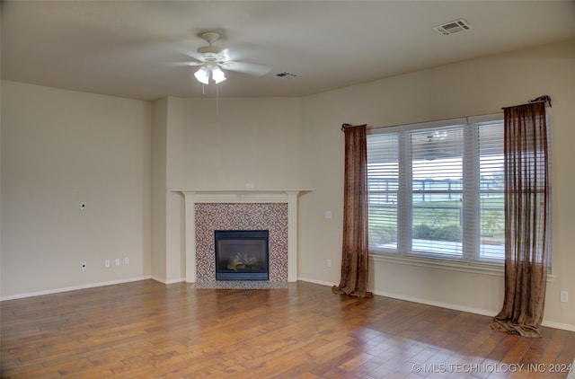 unfurnished living room featuring a fireplace, ceiling fan, and dark hardwood / wood-style floors