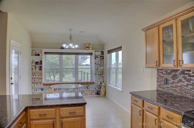 kitchen with plenty of natural light, light tile patterned flooring, and vaulted ceiling