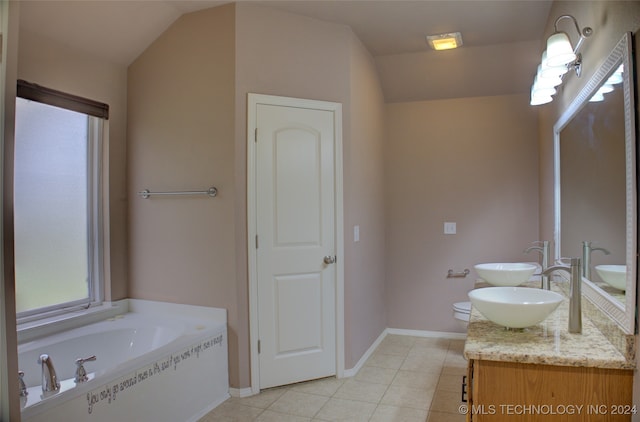 bathroom with lofted ceiling, vanity, tile patterned floors, and a tub