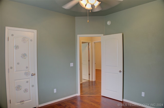 unfurnished bedroom with dark wood-type flooring and ceiling fan