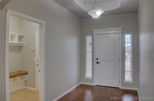 foyer entrance featuring a tray ceiling and hardwood / wood-style flooring