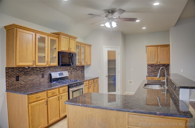 kitchen featuring glass insert cabinets, stainless steel gas stove, a sink, dark stone countertops, and black microwave