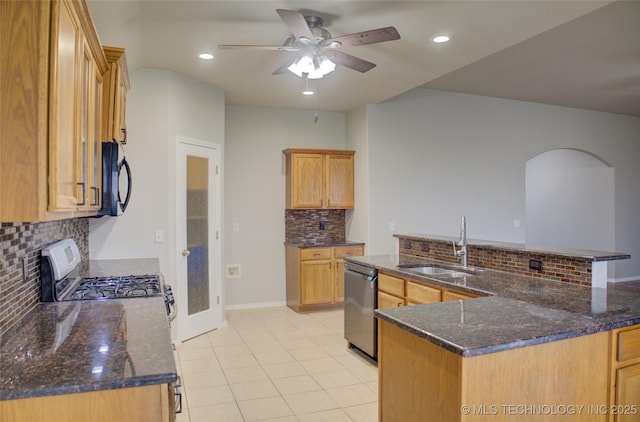 kitchen featuring light tile patterned flooring, stainless steel appliances, a sink, a ceiling fan, and a large island