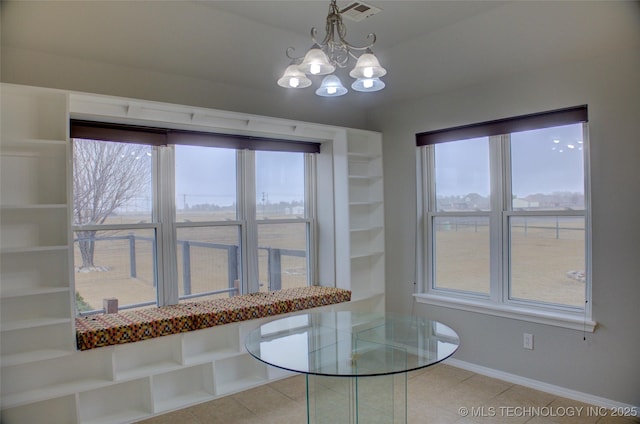 unfurnished dining area featuring an inviting chandelier, baseboards, visible vents, and light tile patterned flooring