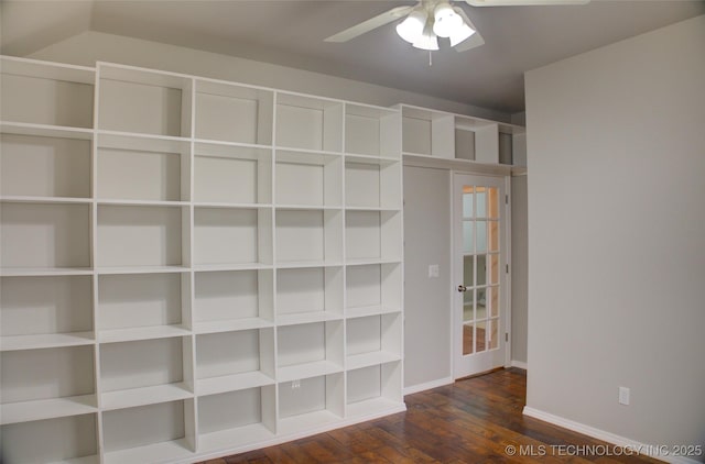 interior space with a ceiling fan, baseboards, and wood finished floors