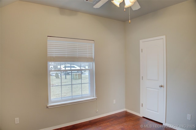 spare room with dark wood-style floors, ceiling fan, visible vents, and baseboards