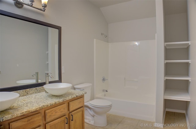 bathroom with double vanity, a sink, toilet, and tile patterned floors