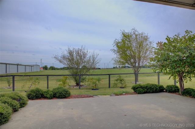 view of patio / terrace with a rural view and fence