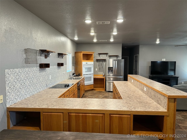 kitchen featuring kitchen peninsula, stainless steel fridge, and light tile patterned flooring