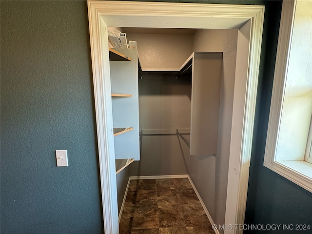 spacious closet featuring dark tile patterned flooring