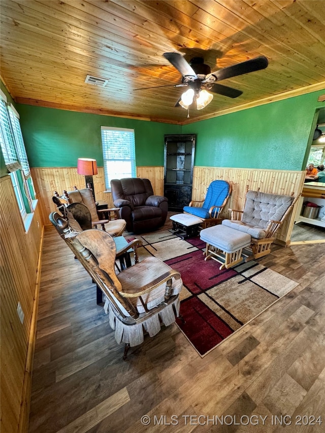 living room featuring ceiling fan, wood walls, wood-type flooring, and wooden ceiling