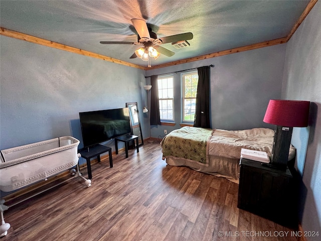 bedroom with hardwood / wood-style floors, a textured ceiling, ceiling fan, and crown molding