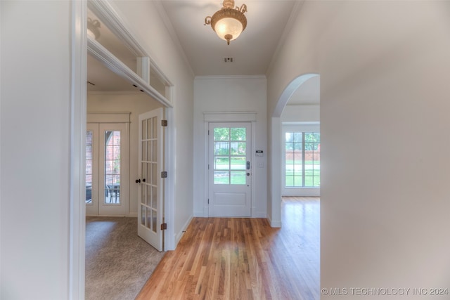 entrance foyer with crown molding and hardwood / wood-style floors