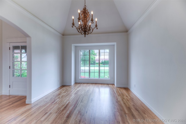 empty room with light hardwood / wood-style floors, a chandelier, crown molding, and lofted ceiling