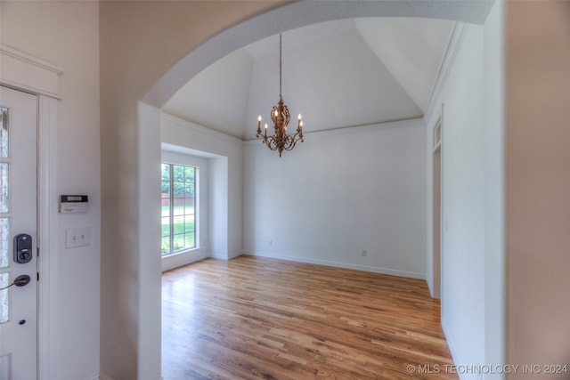 interior space with vaulted ceiling, hardwood / wood-style flooring, and a chandelier